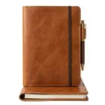 Cognac brown full-grain leather journal cover with brass pen holder and elastic strap on white background - Rove Leather