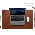 Cognac brown full-grain leather desk pad with MacBook and Apple Magic Mouse on white background — Rove Leather