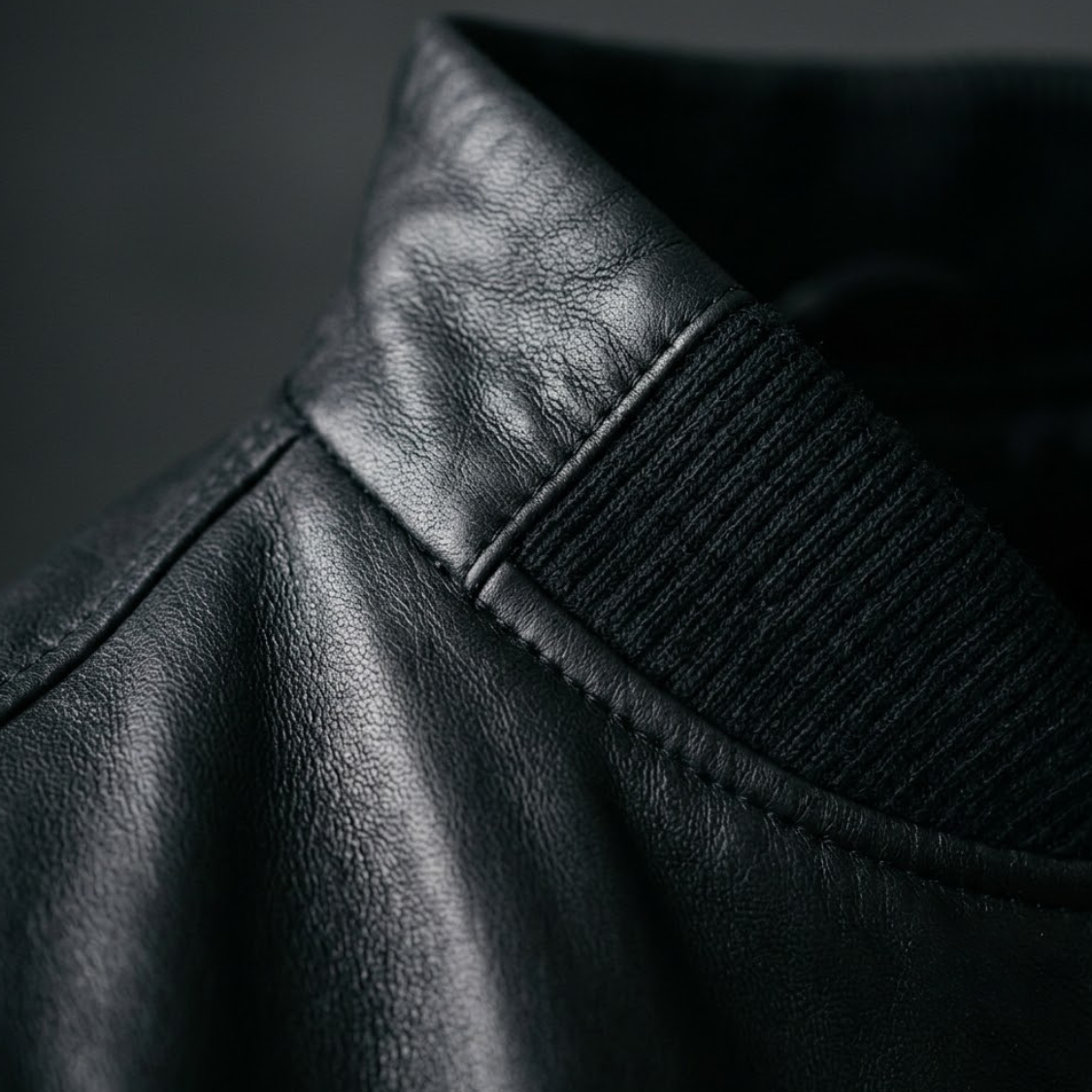 Close up of black lambskin leather bomber jacket collar and ribbed knit trim
