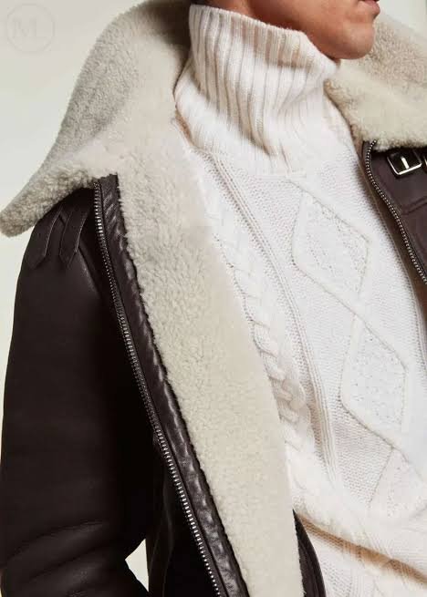 Close up of a genuine brown shearling jacket collar showing dense cream wool lining and smooth leather exterior